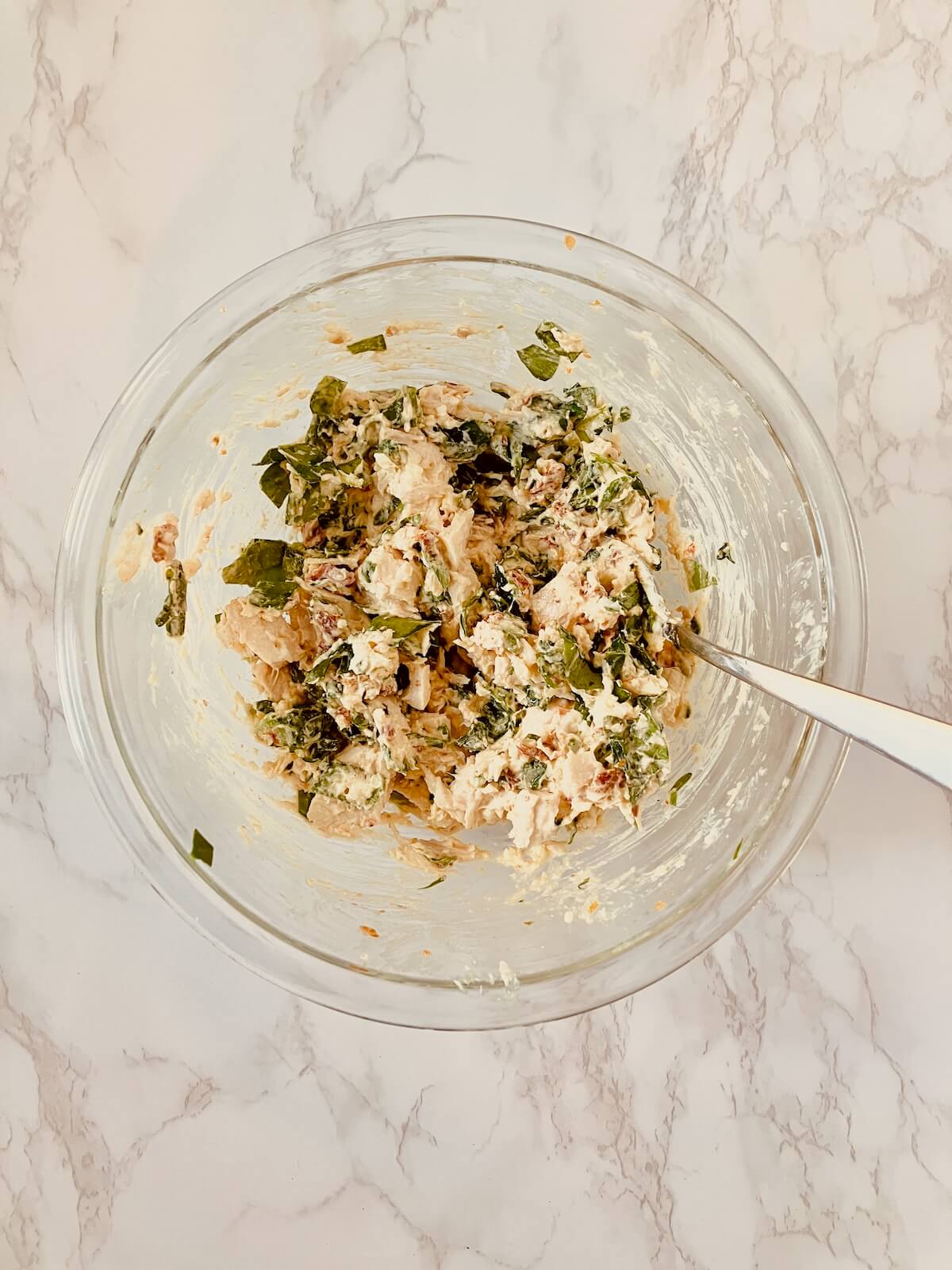 bowl of mixed chicken, cheeses, tomato and basil