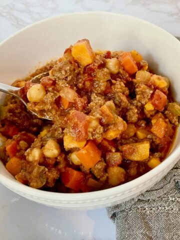 bowl of chickpea chili with a spoon and napkin