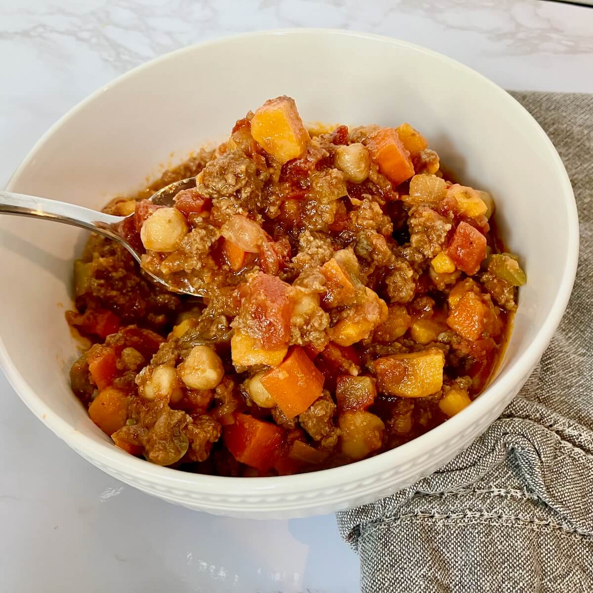 bowl of chickpea chili with a spoon and napkin