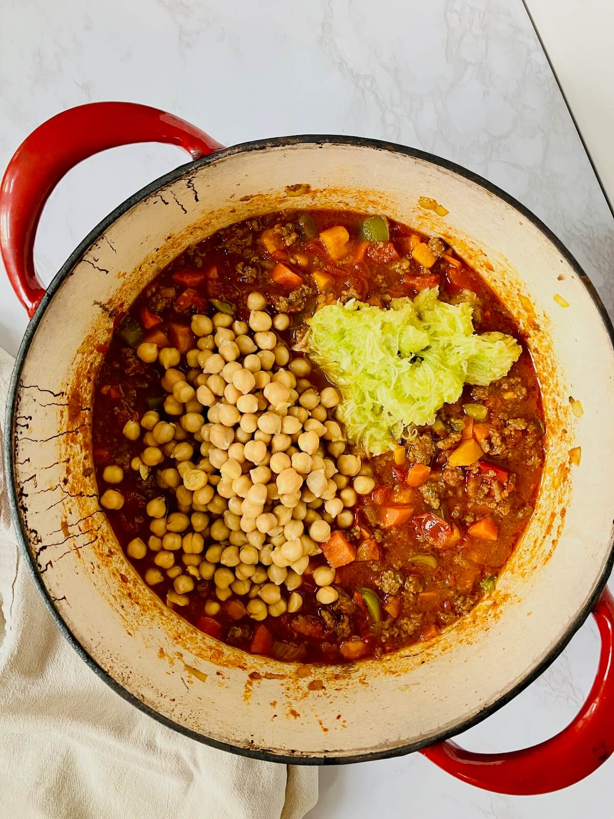 chickpeas and grated zucchini in a pot of chickpea chili