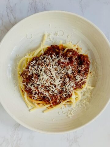 plate of spaghetti with merlot pasta sauce and grated parmasean