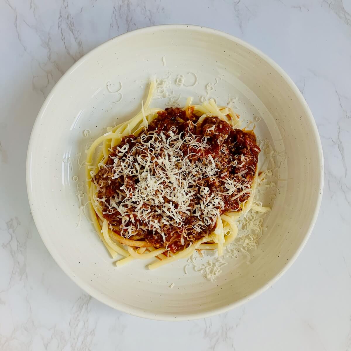 plate of spaghetti with merlot pasta sauce and grated parmasean