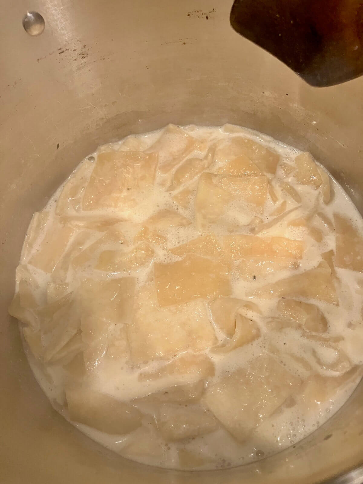 dumplings for chicken and dumplings cooking in a large silver pot