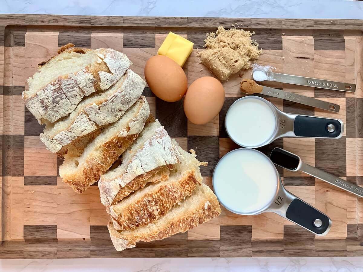 ingredients for sourdough french toast on a wooden cutting board