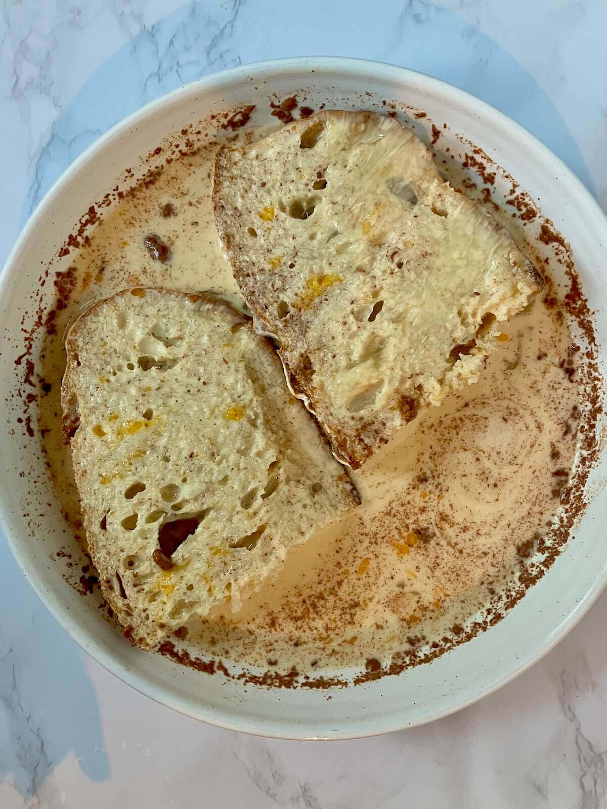french toast slices sitting in egg custard mixture