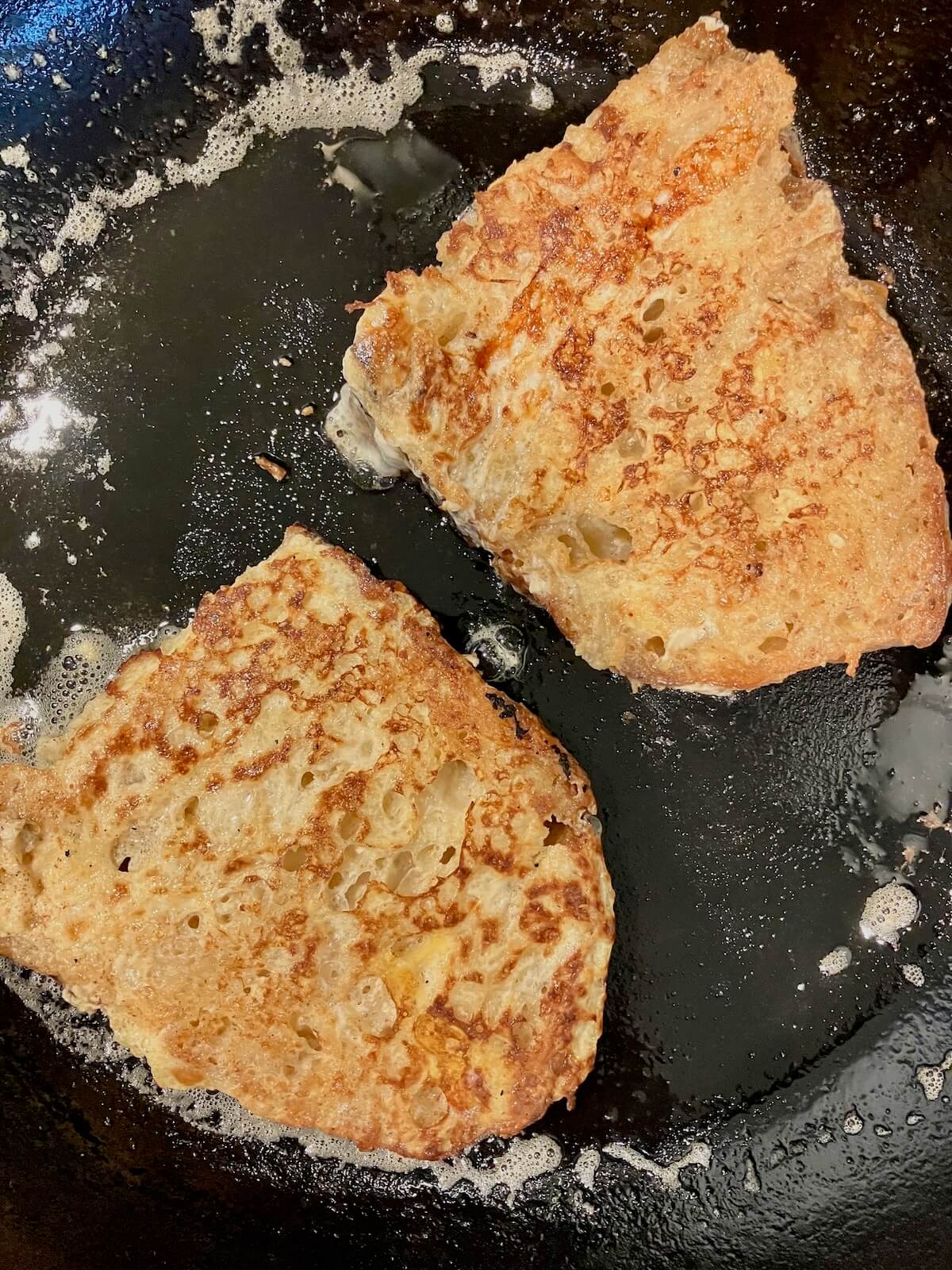 french toast slices browning on a cast iron