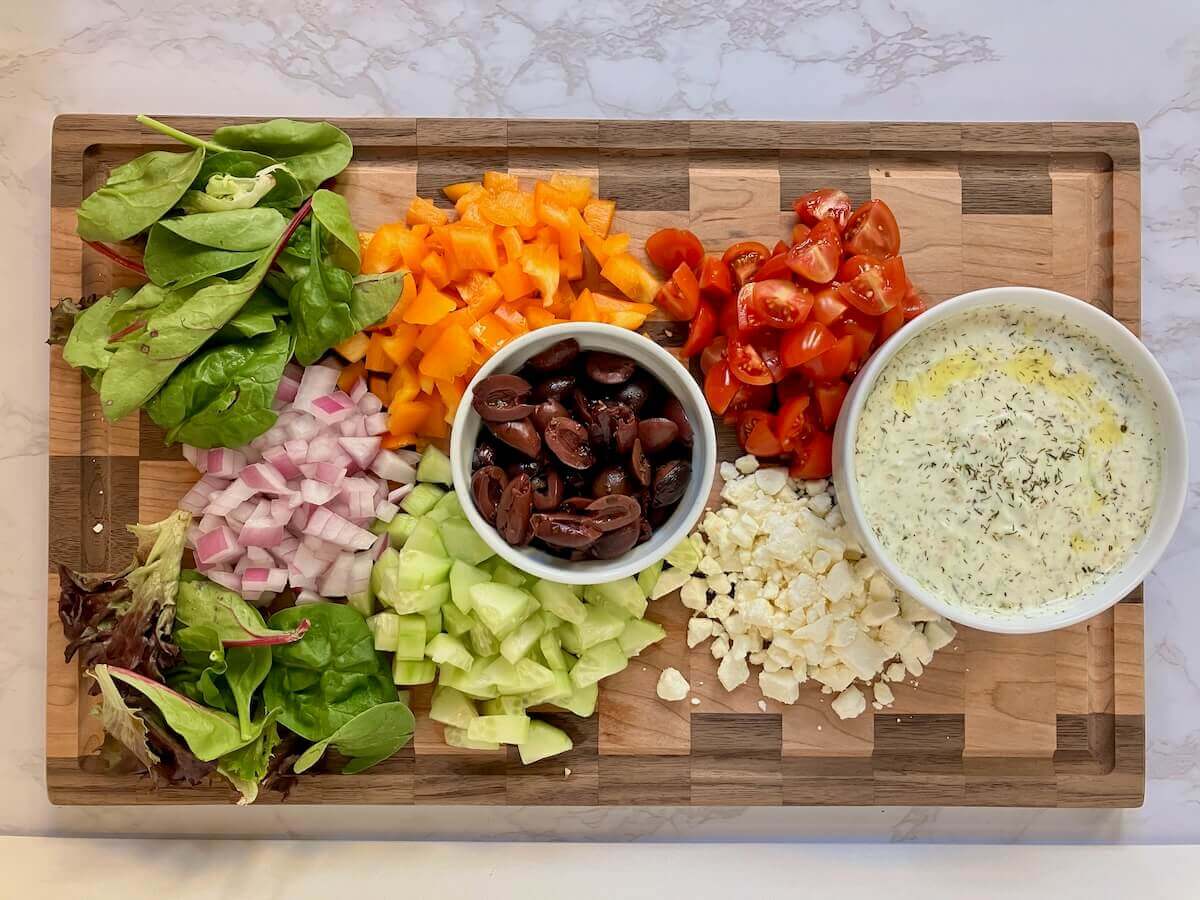 veggie toppings for greek chicken on a wooden background