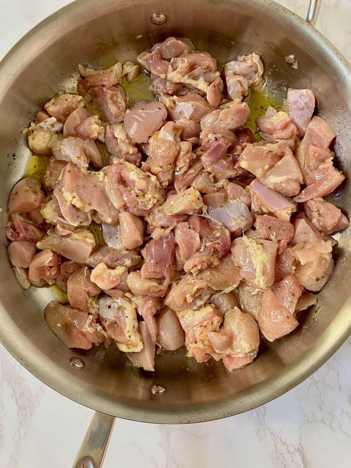 greek chicken in a stainless steel pan