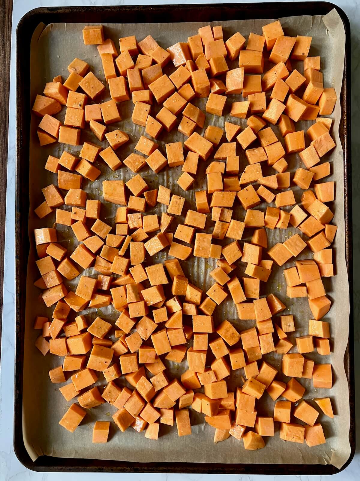 uncooked cubed sweet potato on a baking sheet