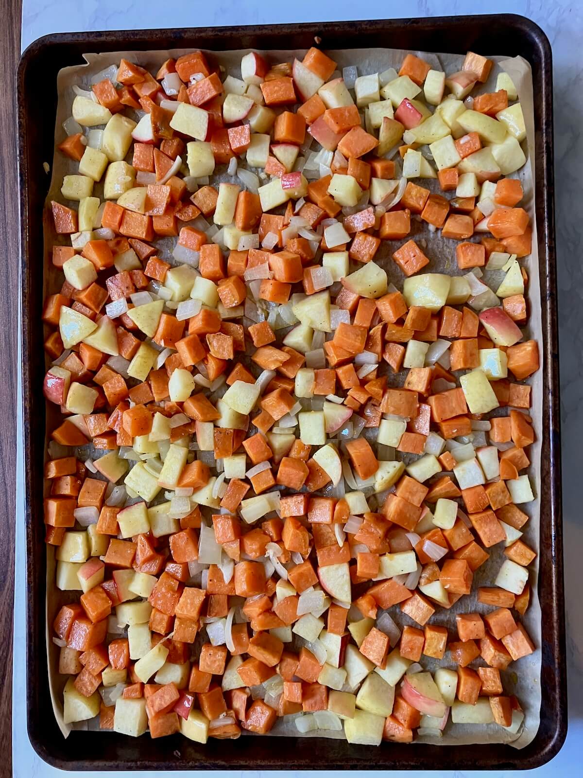 cubed sweet potato and apple on a baking sheet